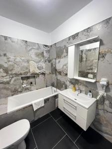 a bathroom with a sink and a tub and a toilet at Luxury Cozy Apartments Suceava in Suceava +36 photos