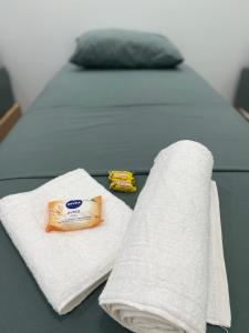 een bed met twee handdoeken op een tafel bij Hospedagem da Lili in Palmas