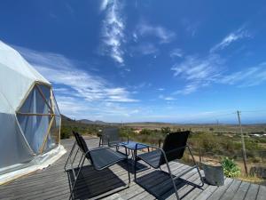a table and chairs on a deck next to a tent at Vilos Domo excepcional domo privado in Los Vilos