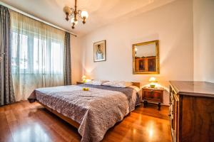 a bedroom with a bed and a dresser and a mirror at Apartment Iva in Rovinj