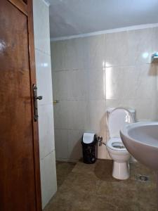 une salle de bain avec des toilettes blanches et un lavabo dans l'établissement Ezba Guest House, à Louxor