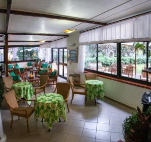 a restaurant with tables and chairs and windows at Hotel Giardino in Capoliveri