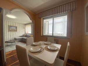 a dining room with a white table and a window at Loft Lugo Centro in Lugo