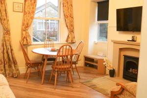 a living room with a table and chairs and a fireplace at Sunrise, 3 east view in Bamford