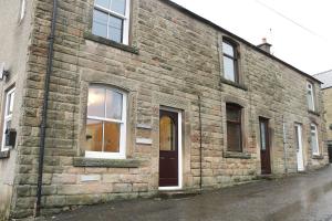 a brick building with a brown door and windows at Sunrise, 3 east view in Bamford