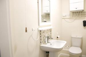 a bathroom with a sink and a toilet and a mirror at Sunrise, 3 east view in Bamford +34 photos