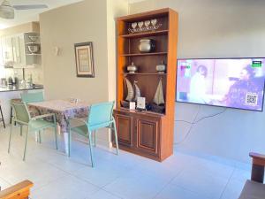 Un comedor con una mesa y un televisor de pantalla plana. en 1 Kiahuna, en Durban