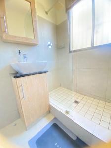 Un baño con lavabo y ducha de cristal. en 1 Kiahuna, en Durban