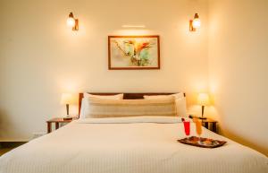 a bedroom with a bed with a plate of food on it at Guldaar Sariska - A Luxury Forest Retreat in Tehla