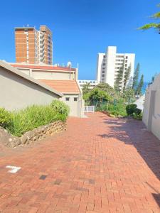 Una pasarela de ladrillos al lado de un edificio con edificios altos. en 1 Kiahuna, en Durban