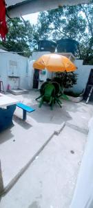 a patio with a green chair and an orange umbrella at Casa na Gamboa do Morro in Gamboa