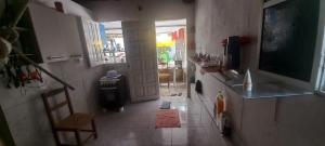 a room with a hallway with a television and a kitchen at Casa na Gamboa do Morro in Gamboa