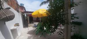 a patio with a yellow umbrella and a green chair at Casa na Gamboa do Morro in Gamboa