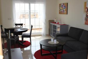 ein Wohnzimmer mit Sofa und Tisch in der Unterkunft Lägenhet högst upp, med pool och utsikt över havet in San Luis de Sabinillas + 16 Fotos