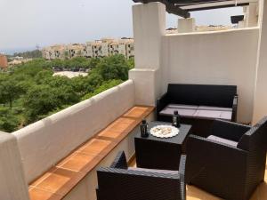 ein Balkon mit einem Tisch und Stühlen auf einem Balkon in der Unterkunft Lägenhet högst upp, med pool och utsikt över havet in San Luis de Sabinillas