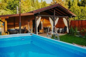 a house with a swimming pool and a pavilion at Kenzo Chalet in Porumbacu de Sus