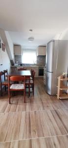 a kitchen with a table and a stainless steel refrigerator at Rigófészek Apartmanház in Gárdony