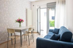 a living room with a blue couch and a table at Altamira Residence in Roseto degli Abruzzi