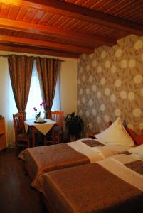 a hotel room with two beds and a table with a table at Pensiunea Faur in Sebeş +11 photos