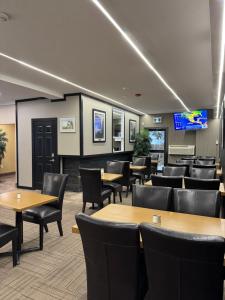 a dining room with tables and chairs and a tv at Big Bird Inn Wawa, SureStay Collection by Best Western in Wawa