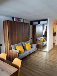 a living room with a couch with yellow pillows at Bilocale Funivie in Breuil-Cervinia