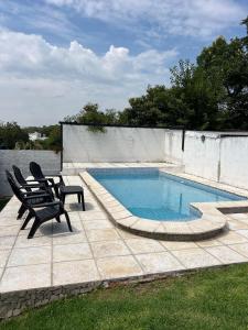 a swimming pool with two lounge chairs next to it at Tres Soles in Salsipuedes
