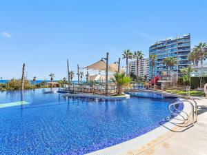 a large swimming pool at a resort with palm trees at Seaview Horizon in Punta Prima