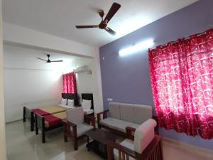 ein Esszimmer mit Tisch und Stühlen sowie einem Deckenventilator in der Unterkunft Naadi stayinn -Premium Rooms in Thanjavur