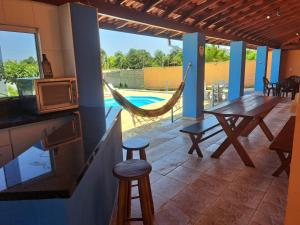 un patio con tavolo, amaca e piscina di Espaço Portal Azul a Casa Branca