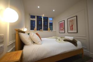 a bedroom with a bed with white sheets and a window at CITYeSCAPE - 1-Bed Apt 1 Bath Sofa bed NQ in Manchester