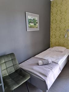 un letto e una sedia in una stanza di Tuhamäe Hostel a Kiviõli