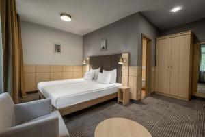 a hotel room with a bed and a chair at Wellton Centrum Hotel & SPA in Riga
