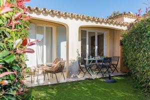 Un patio con una mesa y sillas. en La Petite Grimaud YourHostHelper, en Grimaud