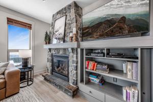 - un salon avec une cheminée en pierre et une télévision dans l'établissement Stonegate Resort Unit C106, à Big White
