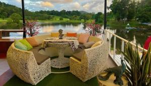 a patio with a couch and a table and a lake at Camping Phuket 88 in Kathu