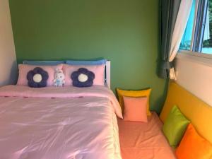 a bedroom with a pink bed with stuffed animals on it at Camping Phuket 88 in Kathu