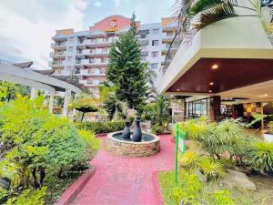 a resort with a fountain in front of a building at Kelsey's Homestay in Davao City