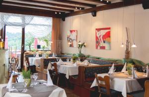 a dining room with tables and chairs with white table cloth at Hotel Restaurant Martha in Wertheim
