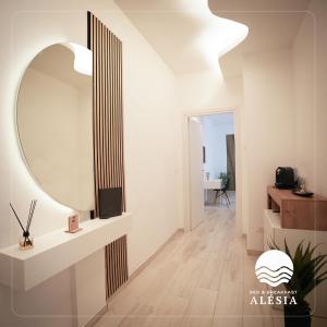 a bathroom with a round mirror and a sink at B&B Alèsia in Montesilvano