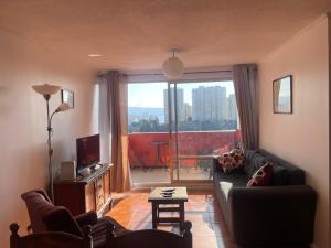 a living room with a couch and a large window at DepartamentoSantaInes in Viña del Mar