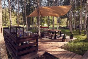 a wooden deck with a picnic table and an umbrella at LES Glamping in Jõemetsa