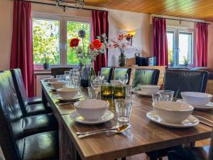 a long wooden table with plates and glasses on it at Haus am Kreuzberg in Medebach
