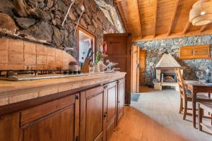 a kitchen with a stone wall and a fireplace at Finca Rural House Tenerife Relax in Santa Úrsula