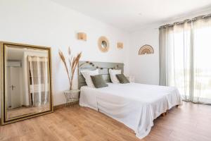 a white bedroom with a large bed and a mirror at Maison accueillante à Roquebrune-sur-Argens avec piscine privée in Roquebrune-sur-Argens +27 photos