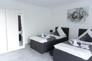 Dos camas en una habitación con espejo. en Lemsdorfer Apartments Magdeburg, en Magdeburgo 65 fotos más