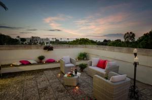 a patio with couches and chairs on a balcony at Masseria La Baronessa Resort in Tuglie