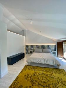 a bedroom with a large bed and a yellow rug at Casa boutique-rural en El Bierzo in Torre del Bierzo