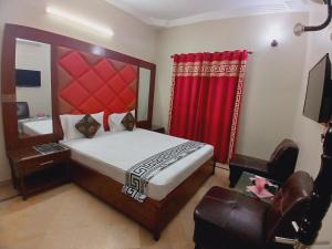 a bedroom with a large bed and a red curtain at Subhan Inn in Karachi