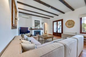 een woonkamer met een grote bank en een tv bij Villas Guzman - Olga in Moraira