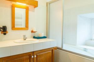 a bathroom with a sink and a mirror at Gîte Gîtes de France 6/7 personnes 3 chambres in Chaulhac +19 photos
